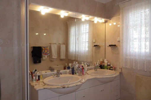 Badezimmer mit Doppelwaschbecken und großem Spiegel