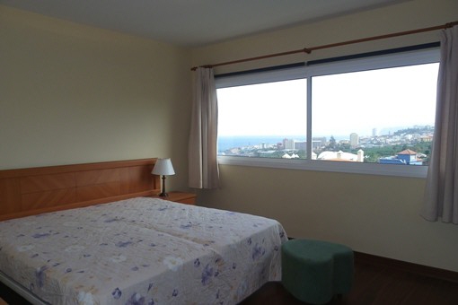 Großes Hauptschlafzimmer mit breiter Fensterfront zum Meer