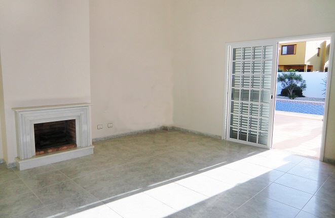 Helles Wohnzimmer mit Kamin und Zugang zur Terrasse